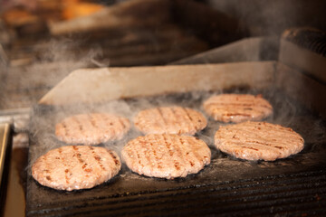Burger meat on the grill with smoke