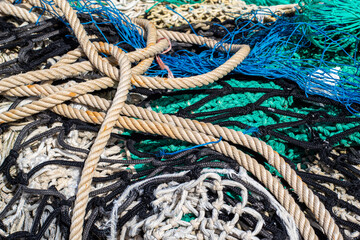 Cuerdas y redes de pesca de varios colores en el suelo del pequeño puerto pesquero del pueblo Blanes en Cataluña.