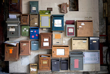 Patchwork de boîtes aux lettres hétéroclites et en désordre dans une entrée d'immeuble