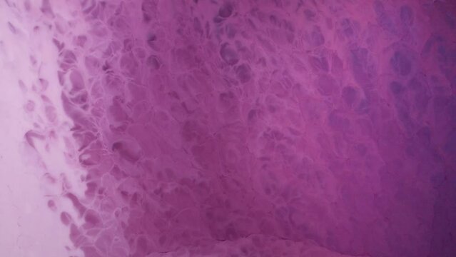  Flowing glitter waving surface. Beautiful metallic pink, purple, lilac texture paint close-up. Liquid slow motion Art. Colorful Chaos Turbulence.