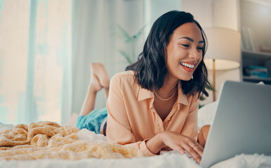 Bed, laptop and relax with a woman blogger or freelance worker doing remote work from home while...