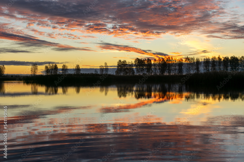 Wall mural beautiful lake at sunrise, golden hour sunrise, sunlight and grand cloud reflections on water, color