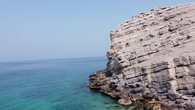Drone shot of rocky mountain beach in Oman