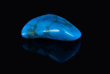 The polished howlite mineral is blue in color with dark veins