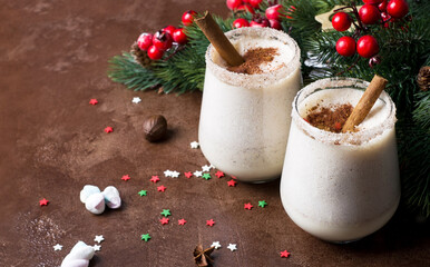 Egg-nog Christmas drink in glass glasses with Christmas decor.