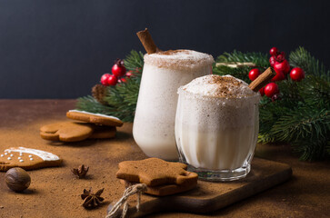 Egg nog Christmas drink on a brown background with gingerbread