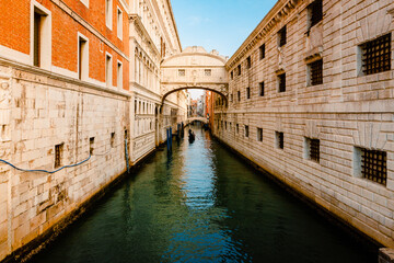 Fototapeta na wymiar The famous Bridge of Sighs, in Baroque style and built of Istrian stone, with gondola crossing the canal