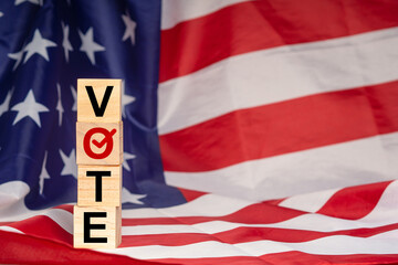 Side view of wooden cubes with letters VOTE on the American flag background