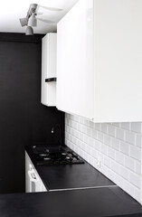 Small  kitchen design with white kitchen cabinets, white kitchen island with lots of storage, black countertops, subway tiles, gas stove.