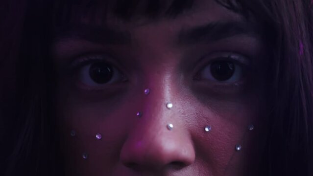 Extreme Closeup Shot Of A Young Woman's Face With Acrylic Crystal Beads With Purple Lights Background.