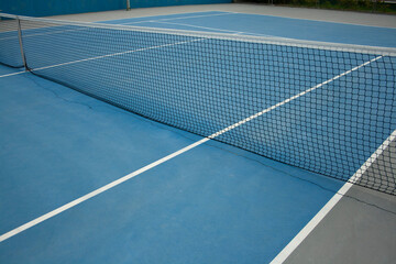 blue tennis court with its lines and net set
