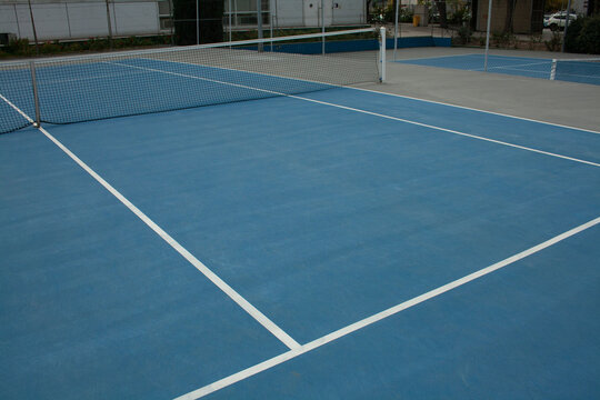 blue tennis court with its lines and net set