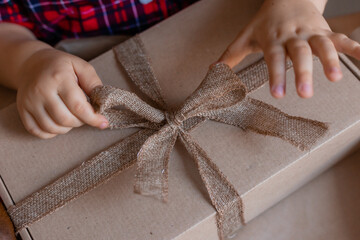close-up of a person's hands tying or untying a ribbon on a gift box