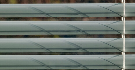 dusty window with horizontal lines of Venetian blinds