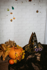 Pumpkin with leaves and a witch hat for Halloween on a rustic wooden background