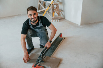 Tile cutting process. The man is making repairs in the apartment