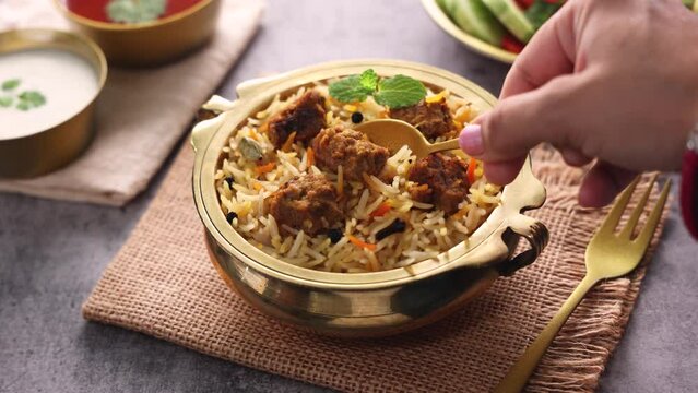 Mutton biryani Spicy Indian Malabar biryani Hyderabadi biryani, Dum Biriyani pulao golden bowl Kerala India Sri Lanka Pakistan basmati rice mixed rice dish with meat curry Ramadan Kareem, Eid