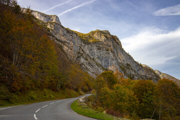 Route surplombée par une falaise en automne