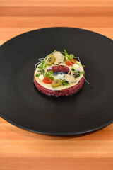 Fresh beef tartar dish with tasty vegetables