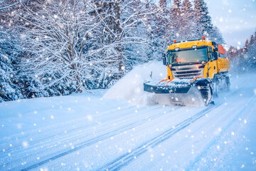 Fototapeta na wymiar Snow plow truck cleaning road in snowstorm.