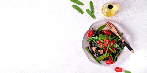 Web banner with black spaghetti pasta served with vegetables: green pea, bean, grilled pepper and...