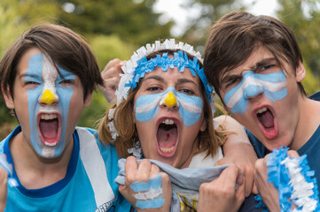 Familia con la cara pintada con los colores de la bandera Argentina alentando al seleccionado en el...