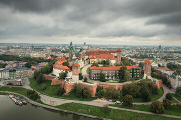 Naklejka na ściany i meble Aerial view of the Wawel hill, with the Royal Wawel Castle, towers and cathedral, Vistula river, background - Old Town on left, Cracow city. Krakow, Poland, September 2022. Cloudy day.