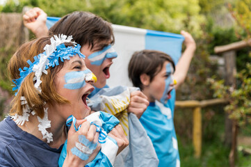 Fanáticos del equipo Argentino de futbol gritando el tanto y alentando.  - obrazy, fototapety, plakaty