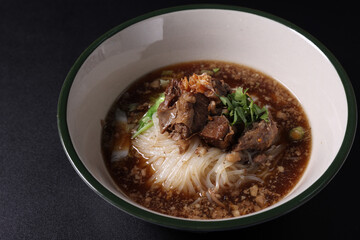 Braised pork noodles Thai street food isolated in black background