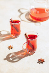 Red tea carcade in glasses armudu and spices. Hard sunlight