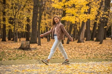 Happy beautiful red-haired woman walking in autumn park