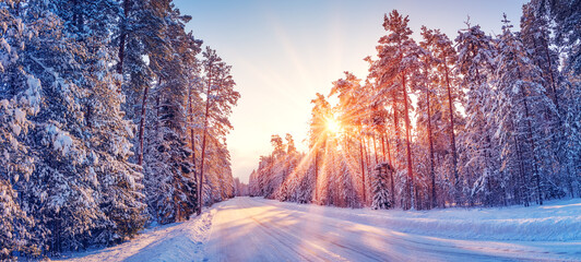 Beautiful view of the sunrise in the morning on the country snowy road. - obrazy, fototapety, plakaty