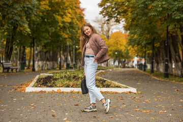 Fototapeta premium Happy beautiful red-haired woman posing in autumn park