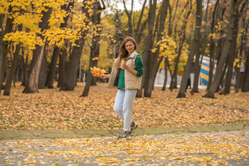 Happy beautiful red-haired woman walking in autumn park