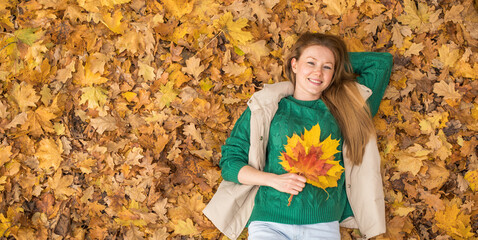 Happy beautiful red-haired woman posing in autumn park
