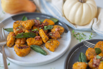 Healthy home made Pumpkin gnocchi with cheese and fresh herbs on a table