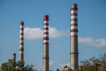 Fototapeta na wymiar Chimneys of thermal power plant on blue sky background