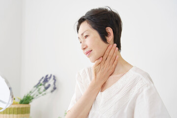 自宅でスキンケアする中年女性