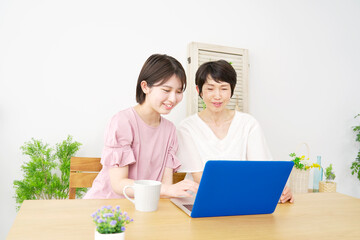 自宅でパソコンを使う娘と母親