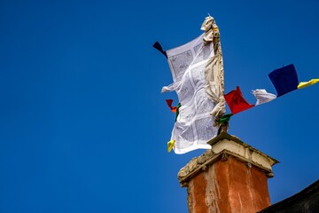 Low angle shot of Tibetan prayer flags on a building in Lo Manthang, Upper Mustang, Nepal