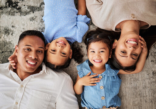 Happy Family, Love And Portrait On Floor By Kids And Parents Bonding In Living Room From Above. Face, Family And Girls Smile, Relax, And Bond With Mother And Father, Laughing And Having Fun On Carpet