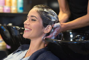 Obraz na płótnie Canvas Hairdresser washing hair of the woman in modern hair salon