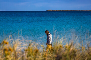 Naklejka na ściany i meble sweet girl in pigtails walks on coral bay beach at sunrise; warm morning on famous paradise beach in western australia, at ningaloo reef