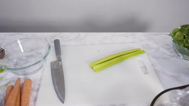 Time lapse. Curring vegetables on a white cutting board to cook vegetarian white bean soup.