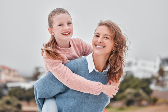 Mother, Child And Piggy Back On Beach On Summer Holiday Smile In Greece. Portrait Of Woman With Girl At The Holiday With Mom, Happy Kid And Vacation With Family Love, Freedom And Fun In A Town