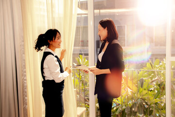 Female manager who runs luxury hotel or resort pays attention to the work of the female maid...