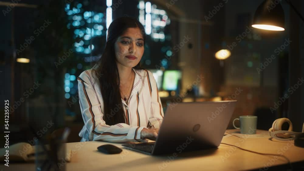 Aufkleber young diverse accountant working in the office late in the evening. positive female using laptop com