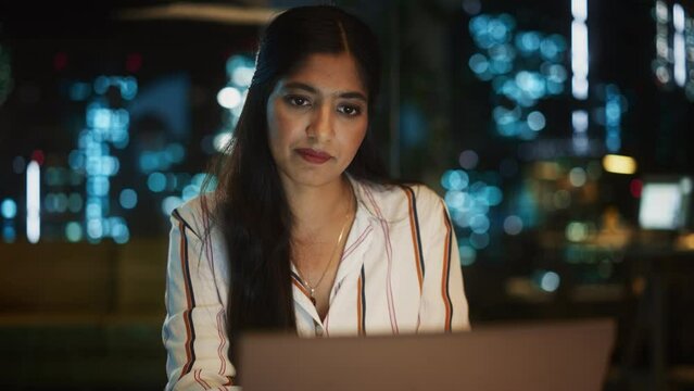 Indian Female Working in Creative Agency in the Evening, Implementing Modern Business Strategy for Clients. Successful Specialist Using Laptop Computer for Serious Work.