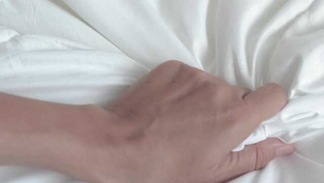 woman hand hold outstretched on white blanket morning bedroom interior.girl palm hold tight the cover.calm relaxed morning or sexual relationship concept 4k real time open palm move fingers young 