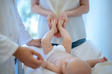 Surgeon checking babys limbs and moving them